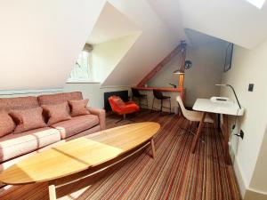 a living room with a couch and a table at Hartnoll Hotel in Tiverton