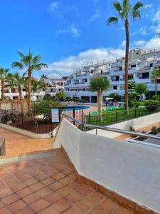 a resort with palm trees and buildings in the background at Victoria Court Modern 1 Bed Apartment Los Cristianos Tenerife in Los Cristianos