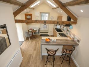 una cocina y sala de estar en un loft reconvertido con vigas de madera en Glan Meon Cottage, en Barmouth