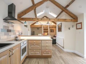 a kitchen with wooden cabinets and a ceiling with skylights at Glan Meon Cottage in Barmouth