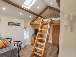 Una escalera que conduce a una cama elevada en una habitación en Glan Meon Cottage, en Barmouth