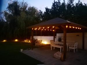 a gazebo with lights and a table and chairs at VeleLak in Velence