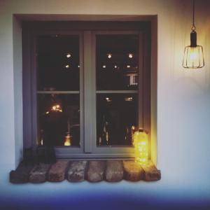a window with a lit candle and some bread at VeleLak in Velence