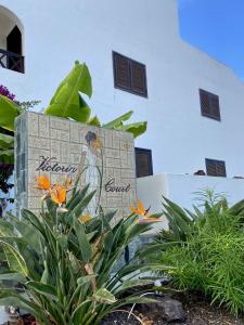 a painting of a woman on a wall with flowers at Victoria Court Modern 1 Bed Apartment Los Cristianos Tenerife in Los Cristianos