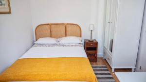 a bedroom with a bed with a yellow blanket at Casa da Bungavillia in Machico