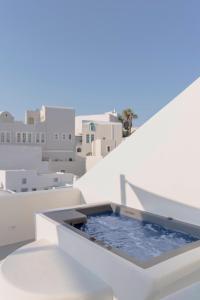 a plunge pool on the side of a white building at Thallos Cave House and Apartments in Karterados