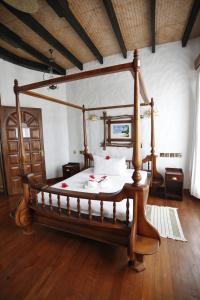 a canopy bed in a room with a wooden floor at La Digue Emerald Villa in La Digue