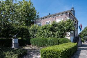 a brick building with a bush in front of it at B&B 't Raethuys in Dirkshorn