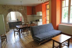 a living room with a blue couch and a table at Gîte de Truyère in Entraygues-sur-Truyère