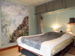 a bedroom with a bed with a large painting on the wall at Holiday Home Pavillon Asiatique by Interhome in Loctudy