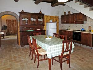 a kitchen with a table with chairs and a white refrigerator at Holiday Home Topano by Interhome in Pianucciole