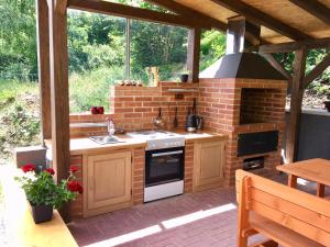 una cocina al aire libre con fogones y un horno de ladrillo en PENZION HNAČOV en Zavlekov
