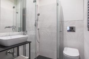 a bathroom with a sink and a toilet and a shower at Apartment Copernicus No. 25 in Toruń