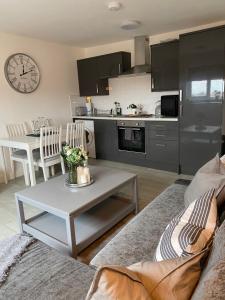 a living room with a couch and a table at Coalhouse Apartment in Seaham