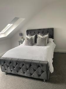 um quarto com uma cama grande com lençóis brancos e almofadas em Coalhouse Apartment em Seaham