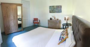 1 dormitorio con cama, tocador y espejo en La Maison du Lac, en Lignan-de-Bordeaux