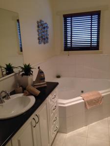 a bathroom with a sink and a bath tub at Salt Air on Banyan in Warrnambool