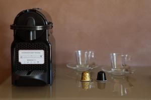 a black blender sitting on a table with two glasses at Hotel Bell'arrivo by Dori in Peschiera del Garda