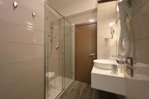 a bathroom with a sink and a glass shower at Hotel Bell'arrivo by Dori in Peschiera del Garda