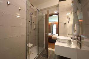 a bathroom with a glass shower and a sink at Hotel Bell'arrivo by Dori in Peschiera del Garda