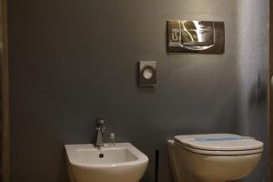 a bathroom with a white toilet and a sink at Hotel Bell'arrivo by Dori in Peschiera del Garda