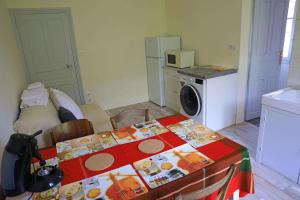 - une cuisine avec une table et un lave-linge dans l'établissement Suite avec vue panoramique sur la Truyère, à Entraygues-sur-Truyère