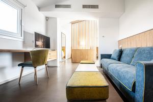 un soggiorno con divano blu e tavolo di Montepetrosu Charming House a Monte Petrosu
