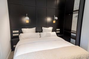 a bedroom with a large white bed with black headboard at La Playa Suites Suances in Suances