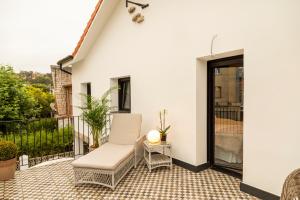 a patio with a white chair on a balcony at La Playa Suites Suances in Suances