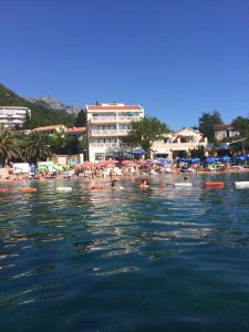 un grupo de personas nadando en el agua en una playa en Andaluni Beach Apartments, en Pržno