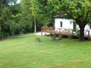 a wooden bench in a yard next to a tree at La Maison du Lac in Lignan-de-Bordeaux