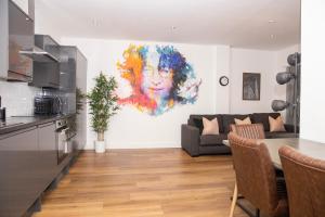 a kitchen and living room with a painting on the wall at SGT Peppers Mathew Street Apartments By Happy Days in Liverpool