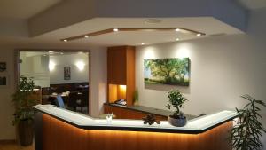 a reception desk with a mirror and plants in a room at Hotel Neue Stuben in Wolfsburg