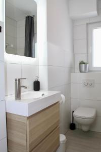 a white bathroom with a sink and a toilet at Apartmenthaus in der Metzstraße in Bochum
