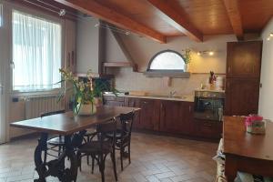 duża kuchnia z drewnianym stołem i krzesłami w obiekcie Casa della Cascata w mieście Predore