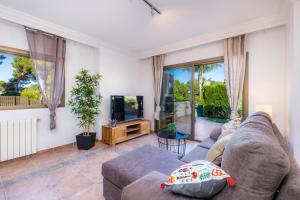 a living room with a couch and a tv at Casa Jordi in Can Picafort