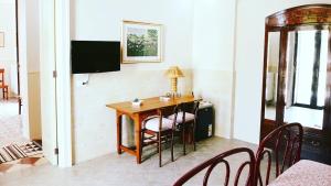 a dining room with a table and chairs and a television at Il Giardino Segreto in Lizzanello