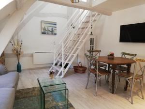 ein Wohnzimmer mit einer Treppe und einem Tisch in der Unterkunft Honfleur-loft in Honfleur