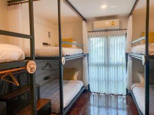 a room with four bunk beds and a window at บ้านในกาด-ที่พักน่าน โรงแรมน่าน เที่ยวน่าน in Nan