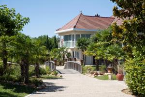 een huis met palmbomen en een loopbrug bij Les Jardins de Beauval in Saint-Aignan