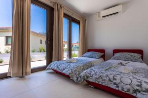 ein Schlafzimmer mit zwei Betten und einem großen Fenster in der Unterkunft VSG Resort - Apartments 200m from Beach, Pool, Sauna & Jacuzzi in Klimno