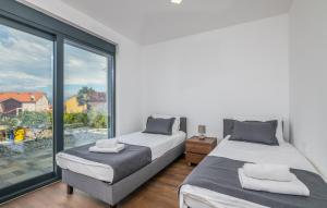 two beds in a bedroom with a large window at VILA STEMARK in Njivice