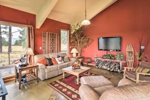 sala de estar con paredes y sofás rojos y TV en Spacious Mountain Home, 10 Mi to Angel Fire Resort, en Angel Fire