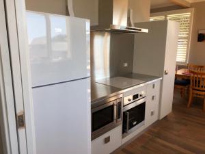 a kitchen with a white refrigerator and a stove at Salt 112 House in Albany