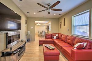 a living room with a red couch and a flat screen tv at Contemporary NOLA Home - Walk to City Park! in New Orleans