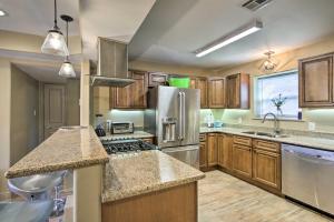 a kitchen with wooden cabinets and stainless steel appliances at Contemporary NOLA Home - Walk to City Park! in New Orleans