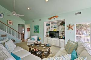 sala de estar con sofá y mesa en Galveston Family Getaway, 1 Block to Beach!, en Galveston
