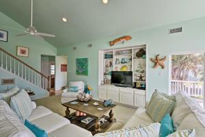 una sala de estar con un sofá y una mesa en 1 Block to Beach Family Getaway in Galveston!, en Galveston