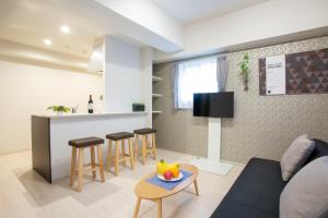 a living room with a couch and a table at BON Condominium Umeda in Osaka