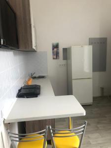 a kitchen with a white counter and a refrigerator at Hostel Raiduzhny in Kharkiv
